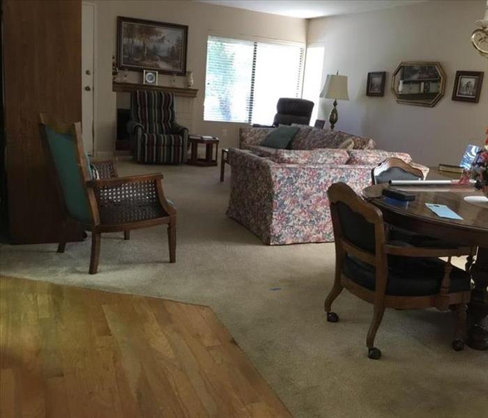 Image of family room on first floor with water damaged wood floors
