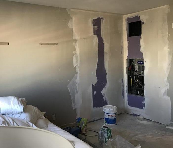 Hotel Bedroom with drywall and mudding with a bed in the background 