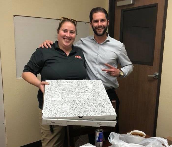 Image of Real Estate Broker, Evan McDonald, with Meghan holding a pizza.